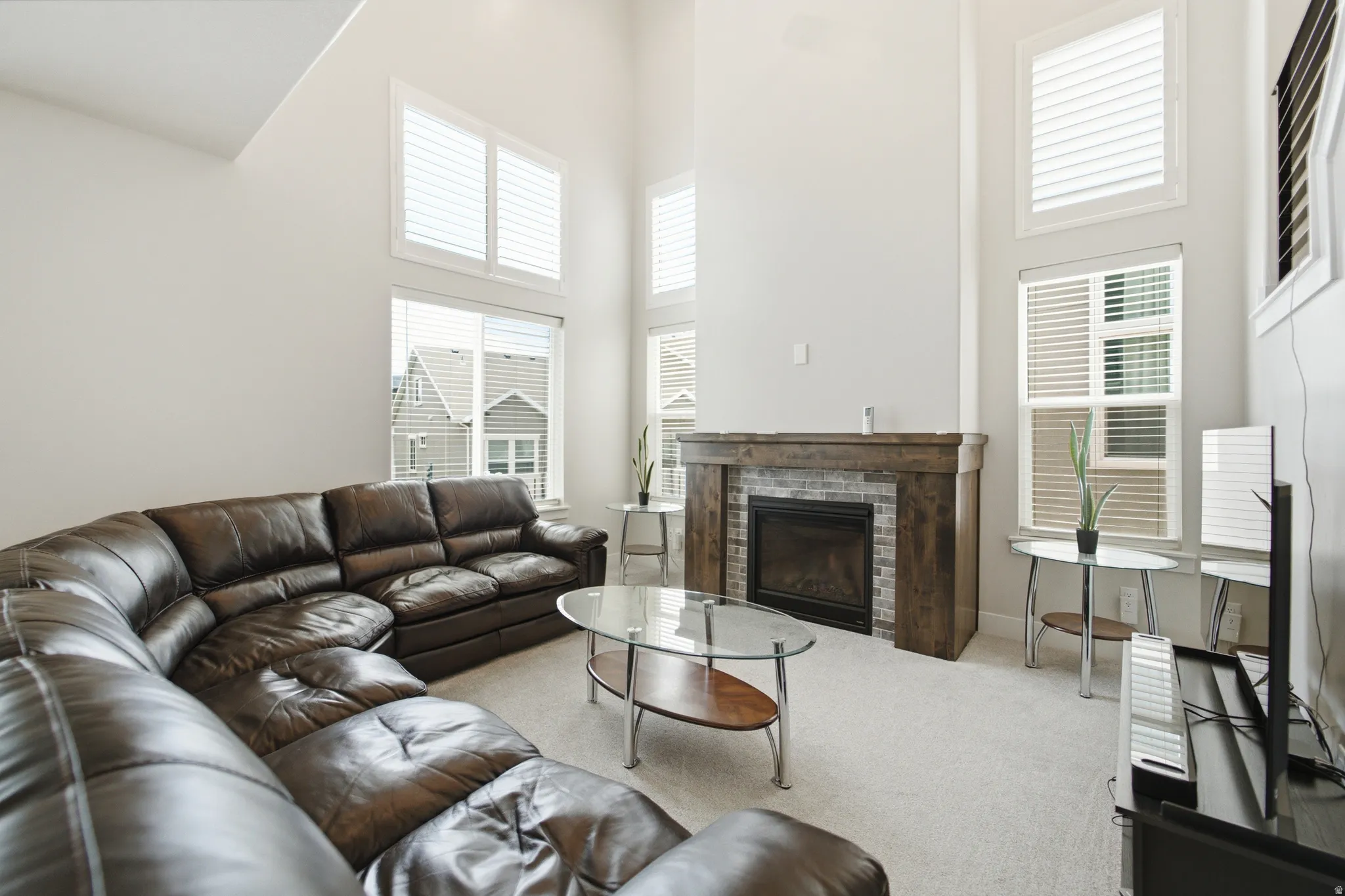 High ceilings and neutral wall tones complement the stone-surround fireplace with wood mantel