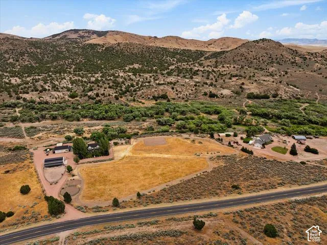 Expansive rural property featuring multiple structures, open fields, and mature tree lines