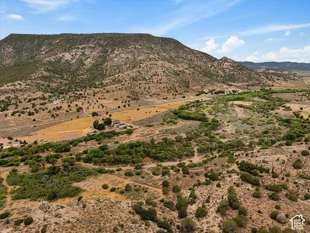 Expansive property featuring a scattered tree line, natural rock formations, and varied terrain