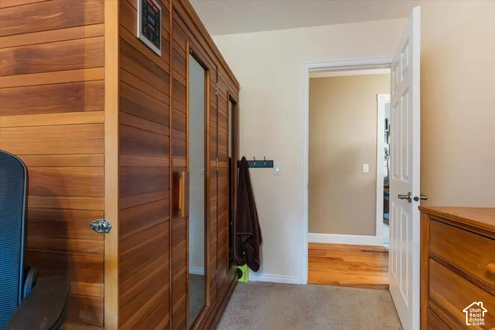 Built-in wood-paneled sauna featuring a glass-paneled door and integrated control panel