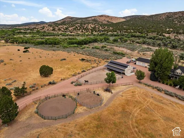 Expansive property featuring a main residence, large barn, detached garage, and two round pens