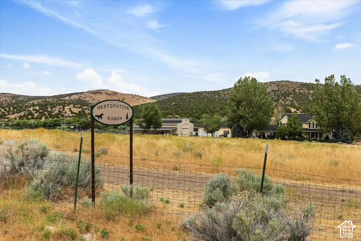 Ranch entrance sign featuring a horse motif, set against a backdrop of rolling hills and mature trees