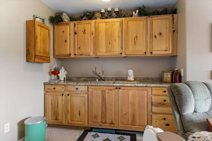 Built-in wood cabinetry with black hardware, complemented by a speckled countertop and a neutral painted wall