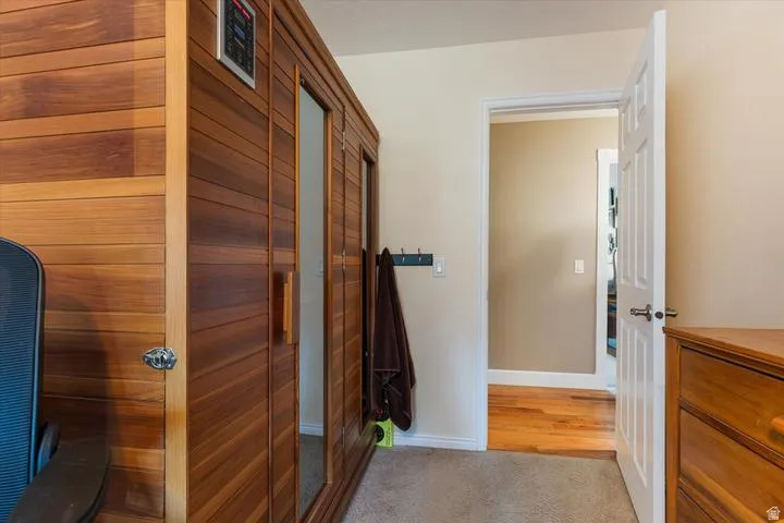 Built-in wood-paneled sauna featuring a glass-paneled door and integrated control panel