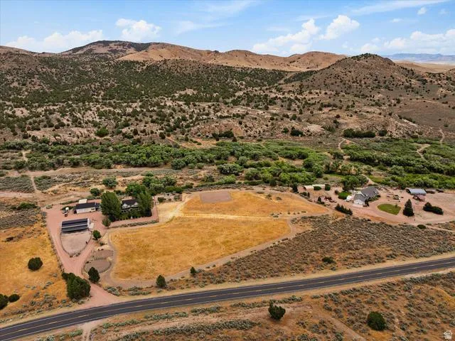 Expansive rural property featuring multiple structures, open fields, and mature tree lines