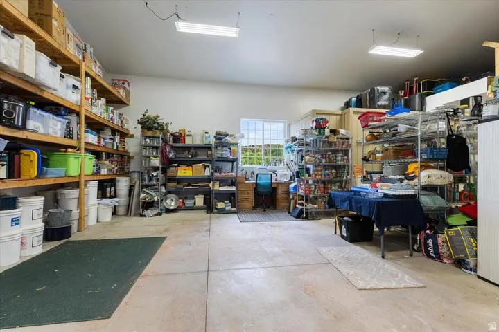 Spacious utility room featuring concrete flooring and ample built-in shelving