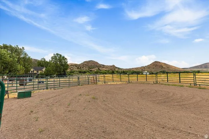 Outdoor riding arena featuring a dirt surface and metal fencing