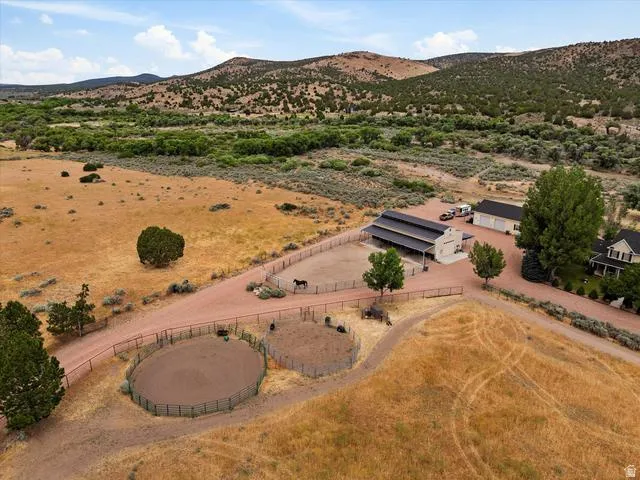 Expansive property featuring a main residence, large barn, detached garage, and two round pens
