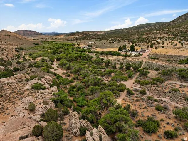Expansive natural landscape featuring varied terrain, including rocky formations and scattered vegetation