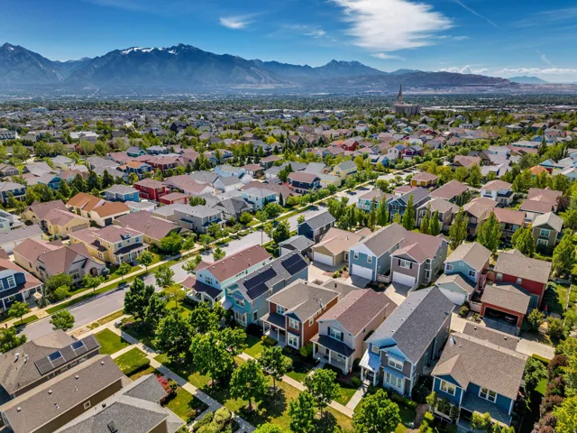 Residential community with diverse architectural styles, mature trees, and mountain scenery