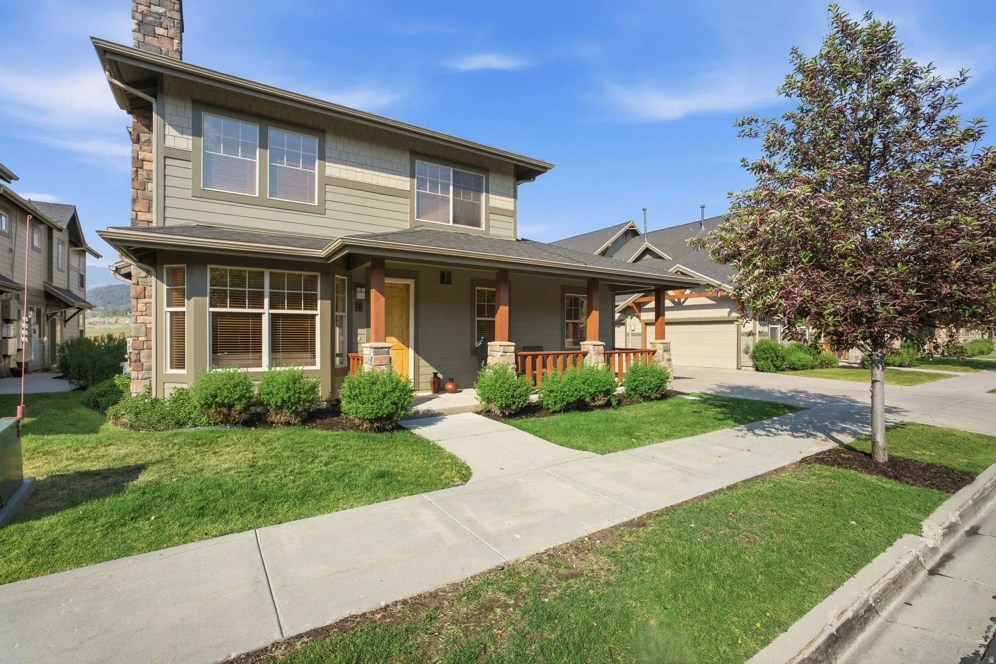 Two-story residence featuring a covered front porch with wood columns and railings