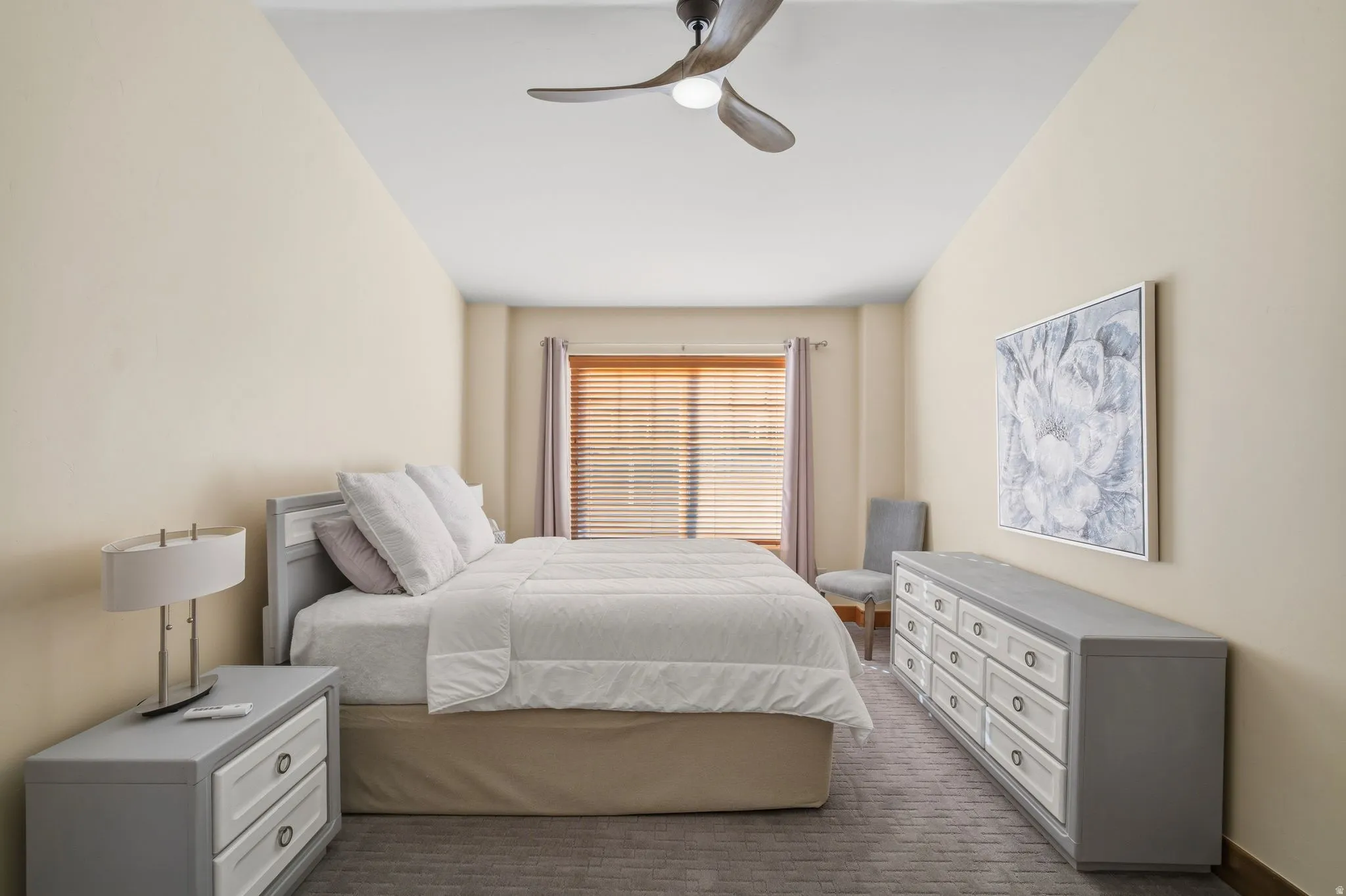 Recessed window with wood-finish blinds and neutral drapes