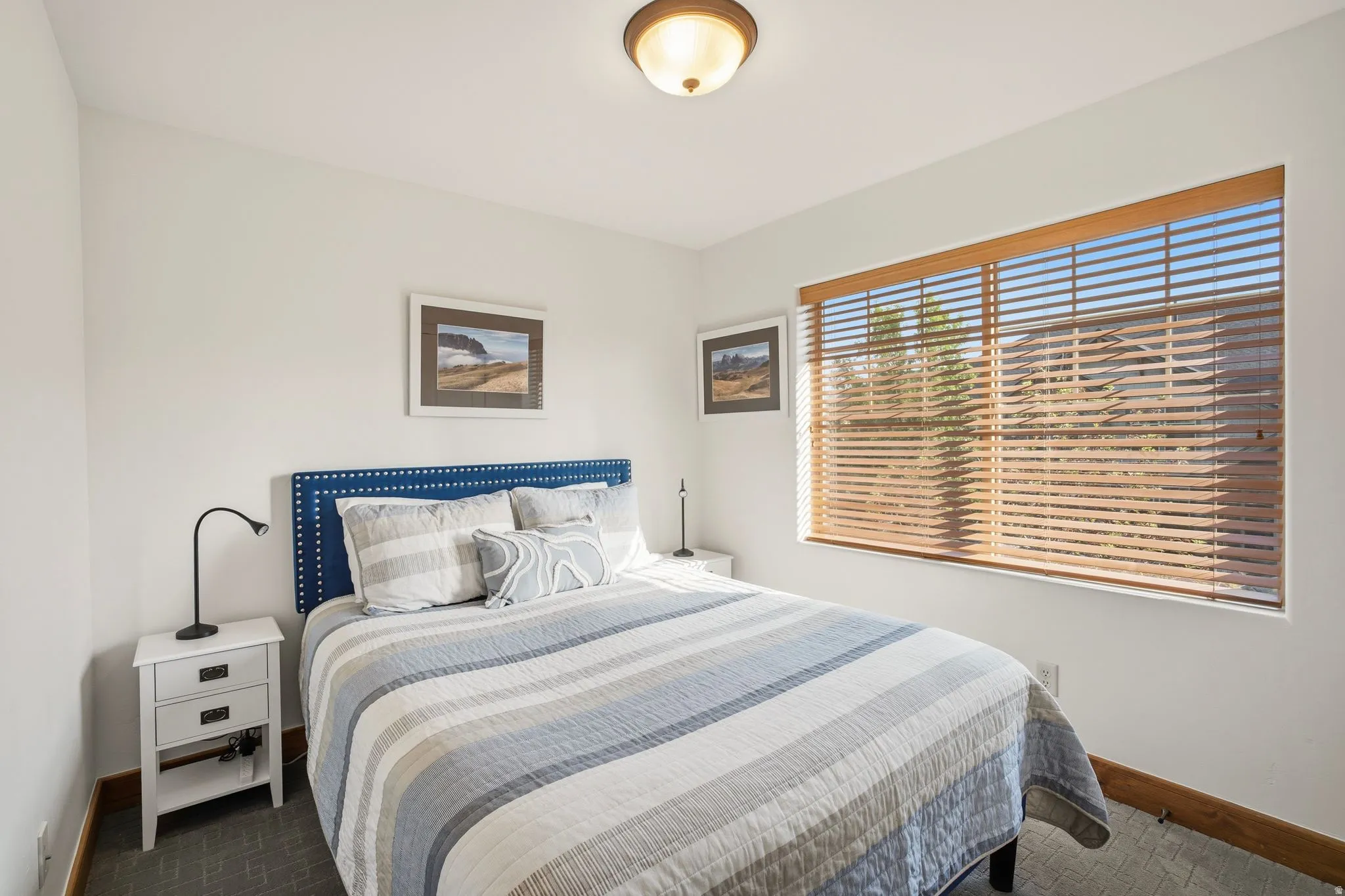 Bedroom featuring white walls, wood-finish window blinds, and a semi-flush mount ceiling light fixture