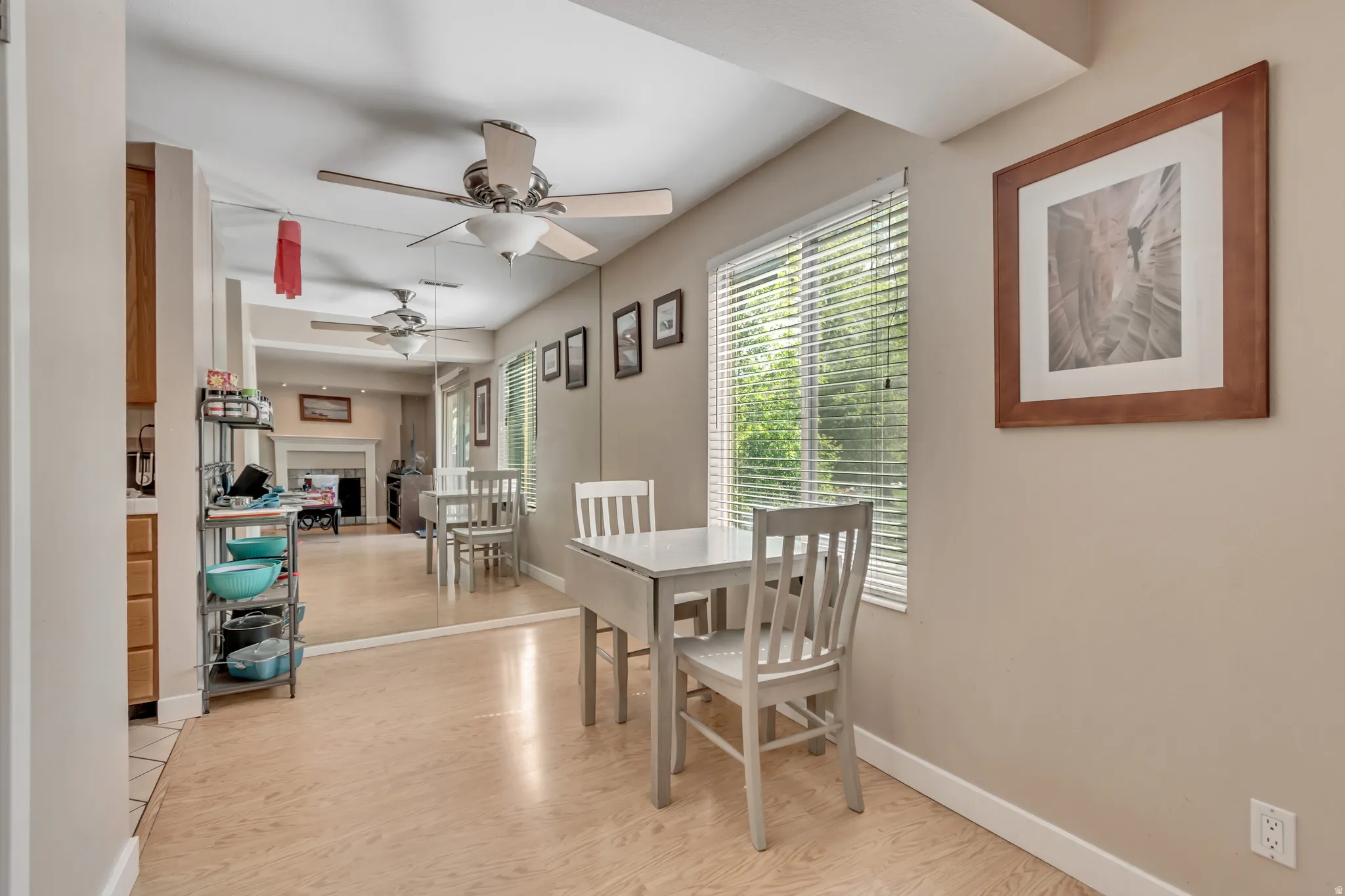 Dining area featuring wood-finish flooring, a ceiling fan, and a window with blinds