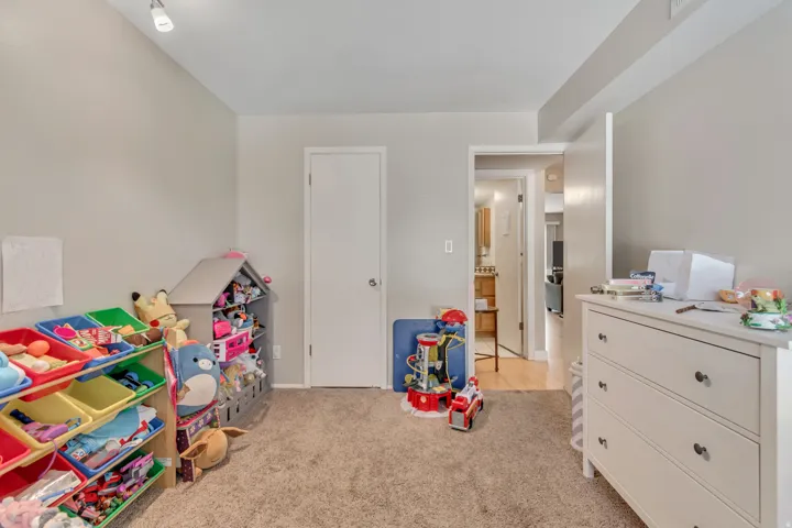 Carpeted room with light neutral wall paint, white trim, and a white interior door