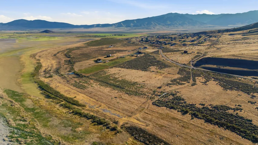 Expansive rural landscape featuring a winding road and distant mountain range