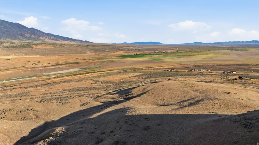 Expansive open land featuring rolling hills and distant mountains