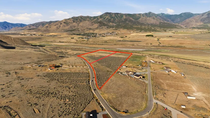 Expansive land parcel featuring natural vegetation and surrounding mountainous terrain