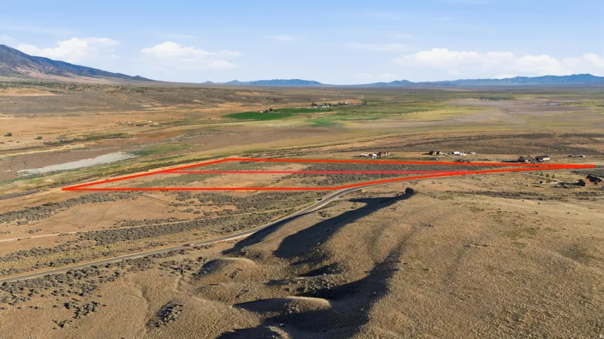 Expansive land parcel outlined in red, featuring a natural, arid landscape with scattered low-lying vegetation