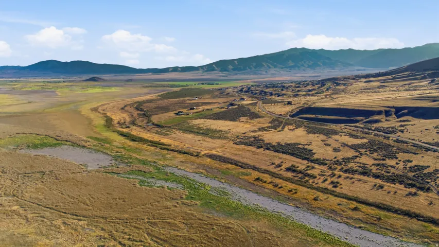 Expansive land parcel featuring natural waterways and distant mountain ranges