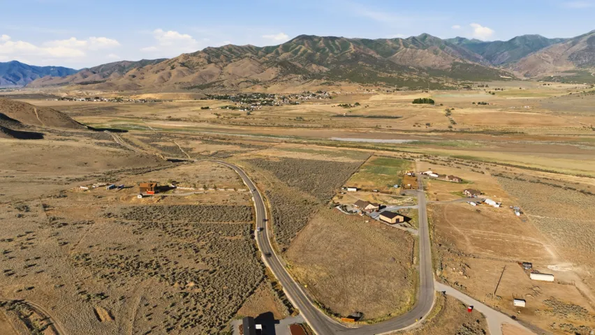 Expansive land parcel featuring existing road infrastructure and mountainous backdrops