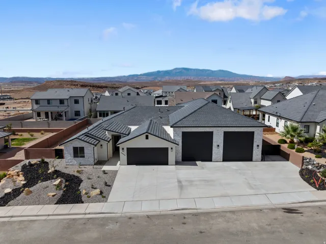 Contemporary single-story residence with a multi-car garage, concrete driveway, and textured roof