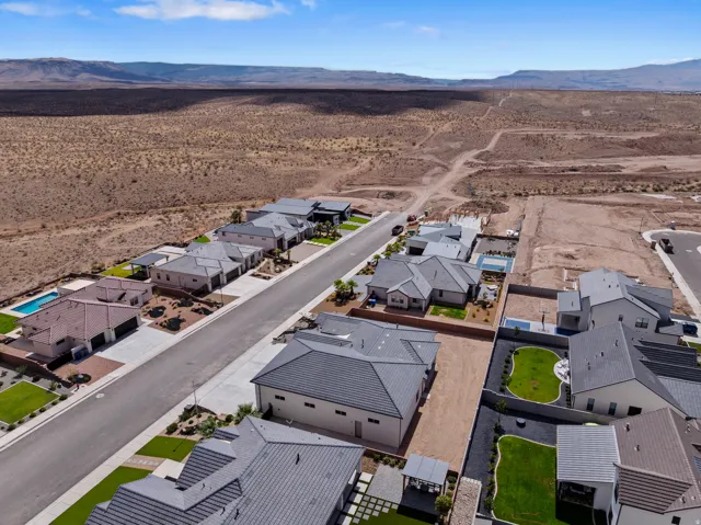Aerial perspective showcasing a collection of modern single-family residences with tile roofs and arid landscaping