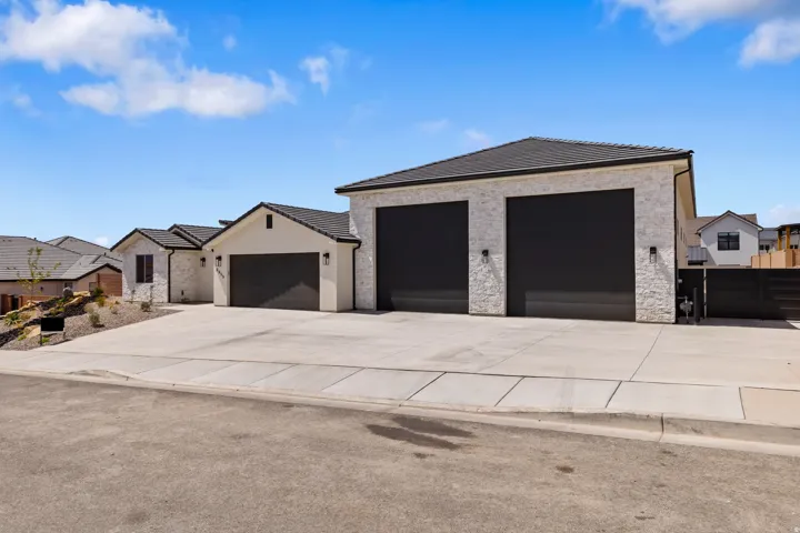 Modern stucco exterior with dark trim accents and a black shingle roof