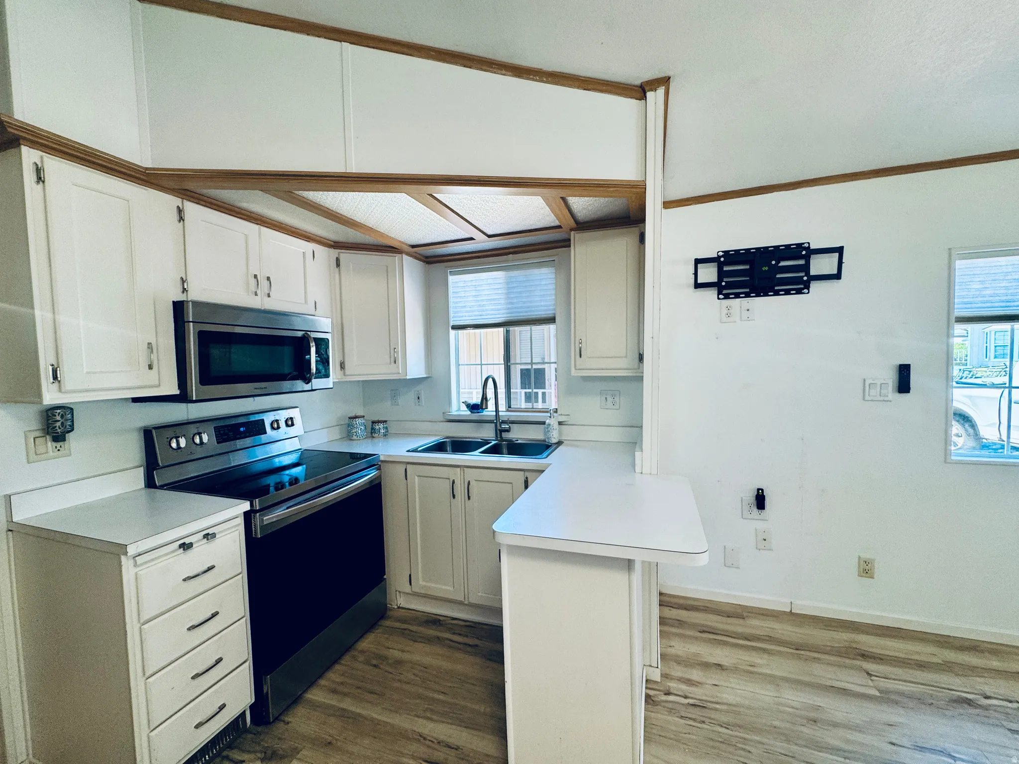 Kitchen featuring wood-finish flooring and white cabinetry