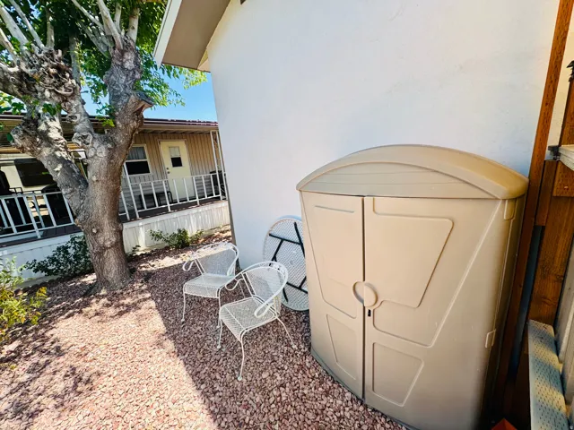 Exterior side yard featuring gravel landscaping and a mature tree