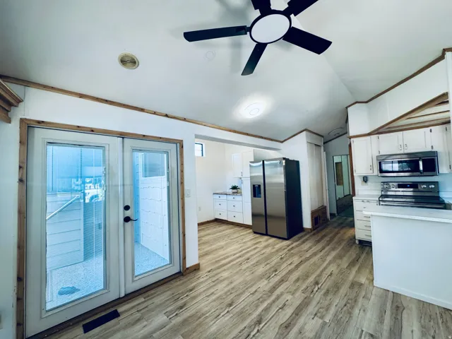 Kitchen area with wood-finish flooring and white cabinetry