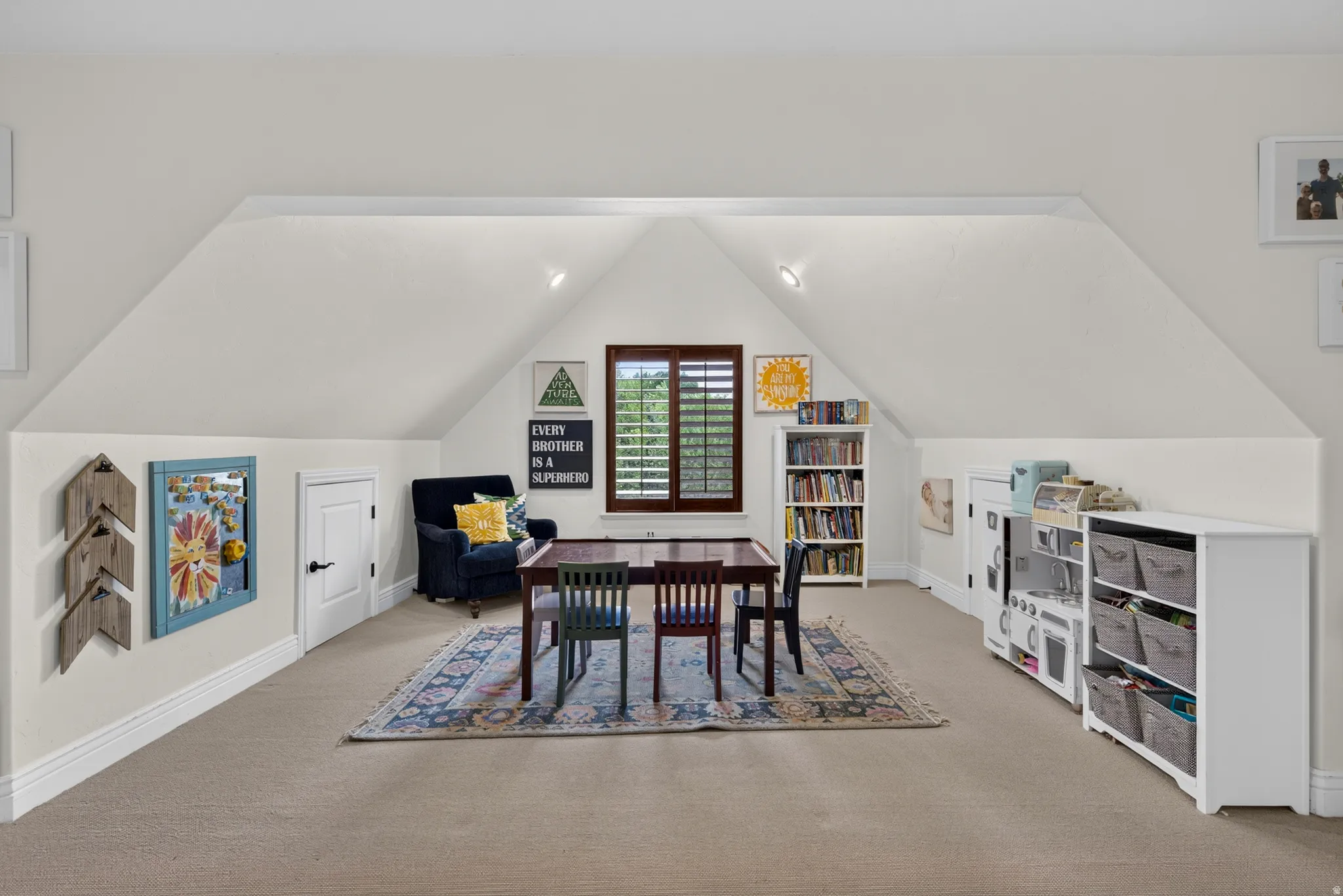 Expansive attic space featuring sloped ceilings and recessed lighting