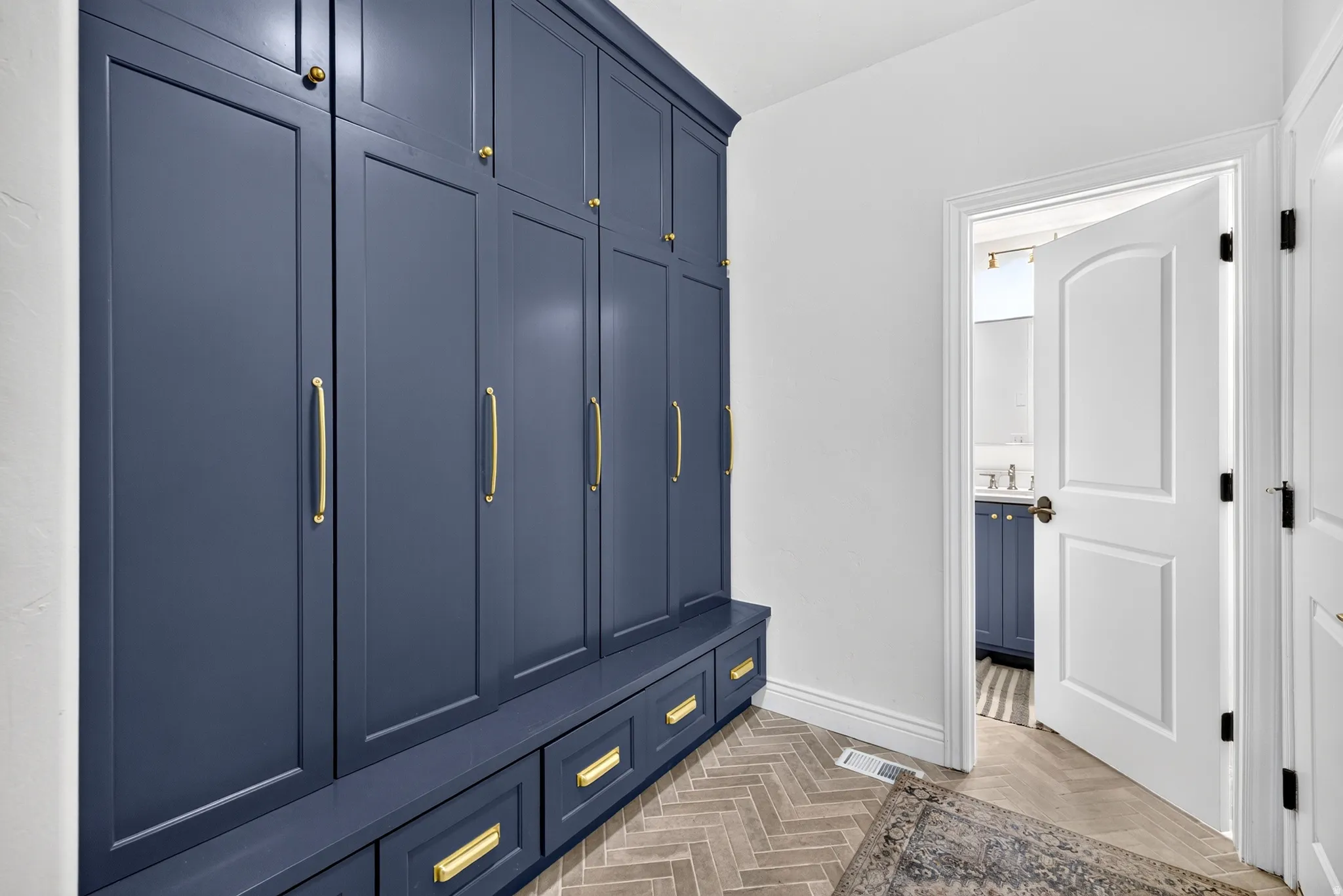 Built-in navy cabinetry with gold-tone hardware, providing extensive storage