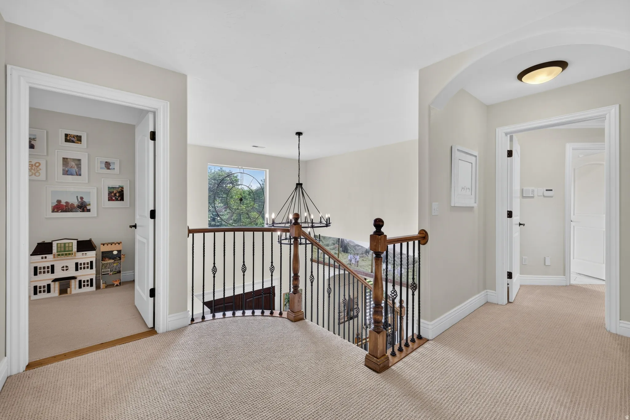Upper-level hallway with neutral carpeting, white trim, and light-toned walls