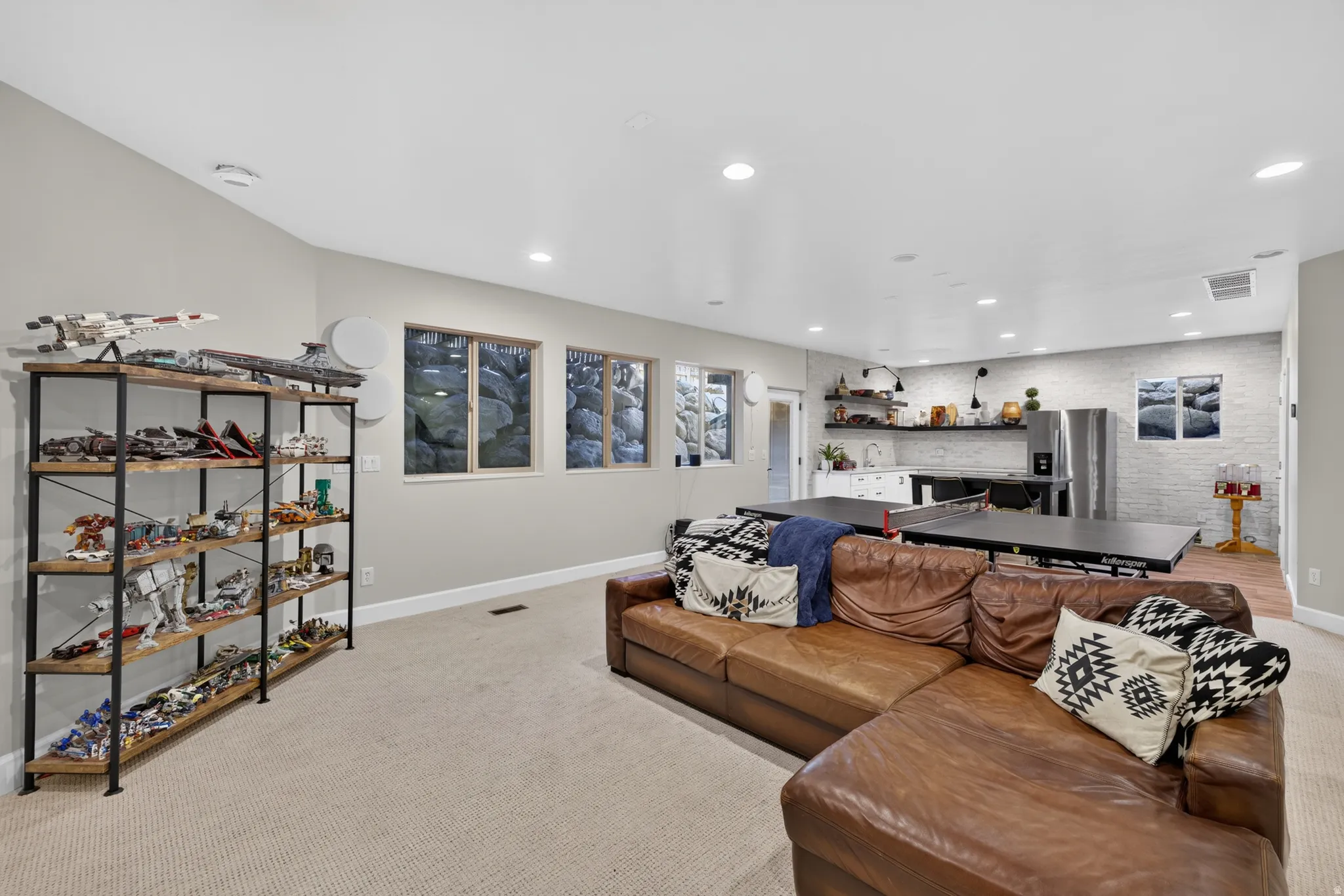 Spacious lower-level living area featuring recessed lighting, light-toned carpeting, and multiple windows