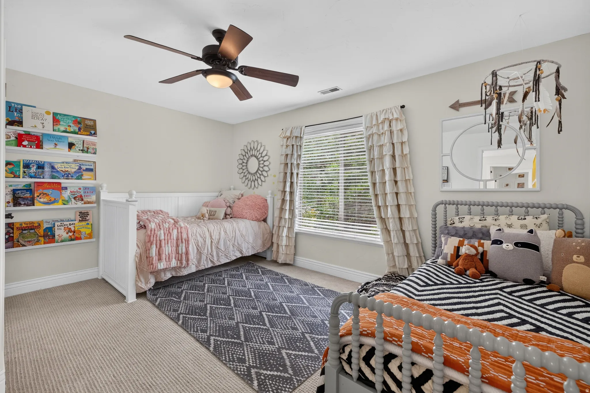 Neutral-toned room featuring a window with blinds, carpet flooring, and a ceiling fan with integrated lighting