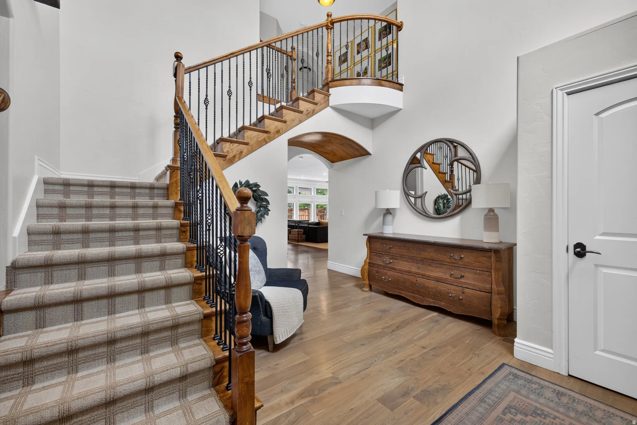 Grand entry featuring a curved staircase with wood treads and a plaid carpet runner