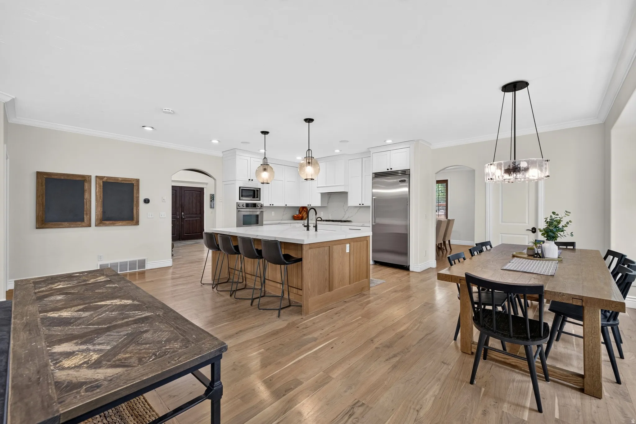 Open-concept kitchen and dining area featuring light wood-finish flooring