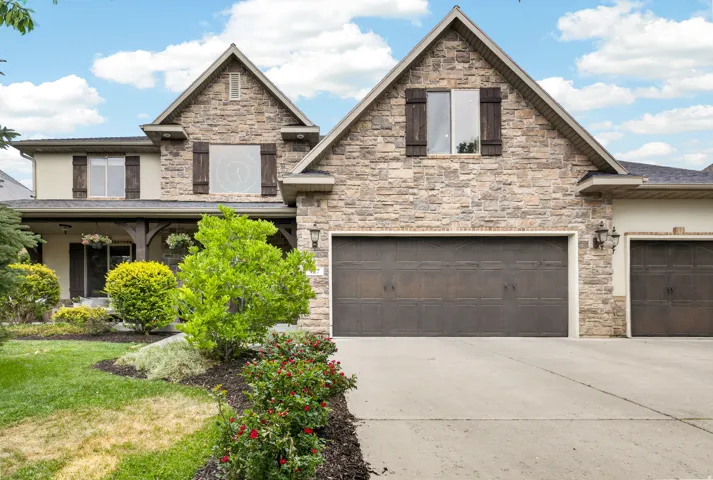 Stone and stucco exterior with dark wood shutters and a prominent gable roofline