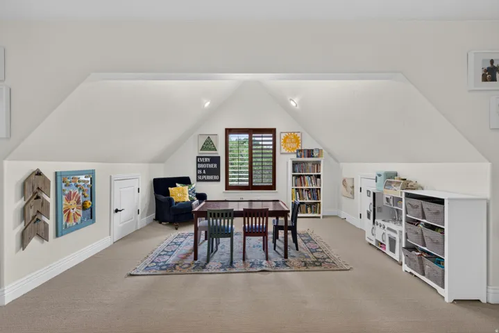 Expansive attic space featuring sloped ceilings and recessed lighting