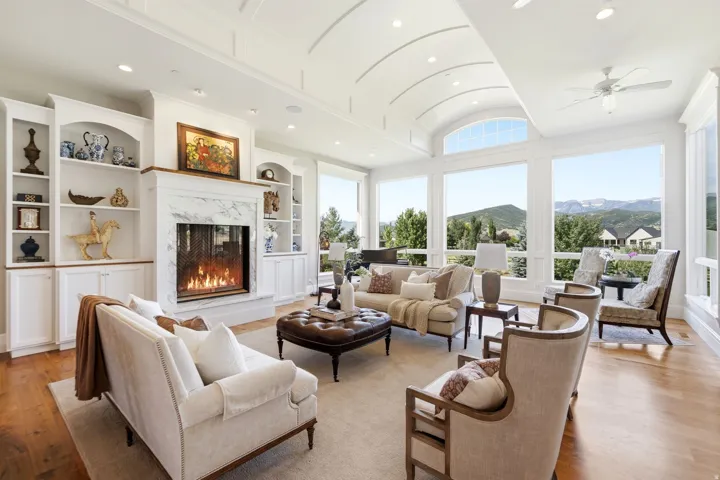 Vaulted ceiling featuring a central arch and recessed lighting, accompanied by a gas fireplace with a marble surround and hearth