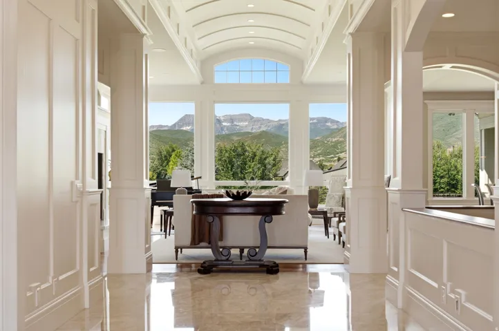 Grand entry hallway featuring polished stone flooring, intricate wainscoting, and an arched tray ceiling