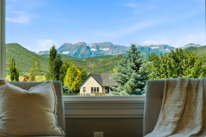 Expansive window framing a mountain range with snow-capped peaks