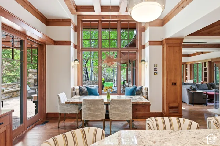 Hardwood flooring, wood-framed windows, built-in banquette seating, recessed wall sconces, and a suspended ceiling fixture