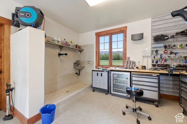 Built-in utility sink, wood-trimmed window, integrated workstation with storage, and slatted wall organization system