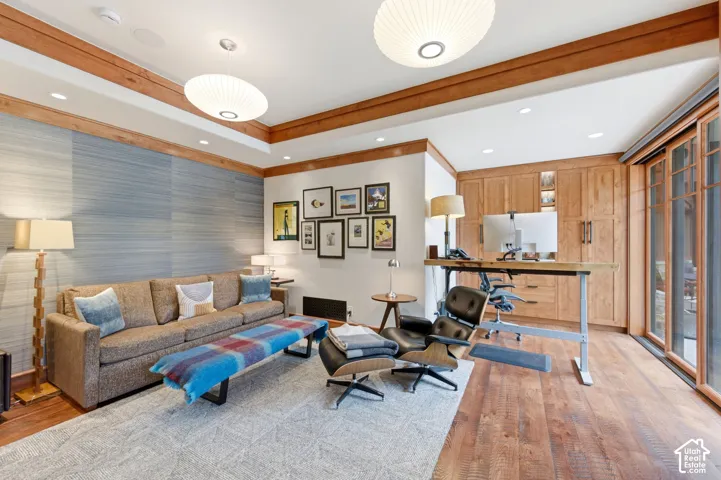Built-in wood cabinetry, wood-finish flooring, wood ceiling beams, sliding glass panel doors, and recessed lighting