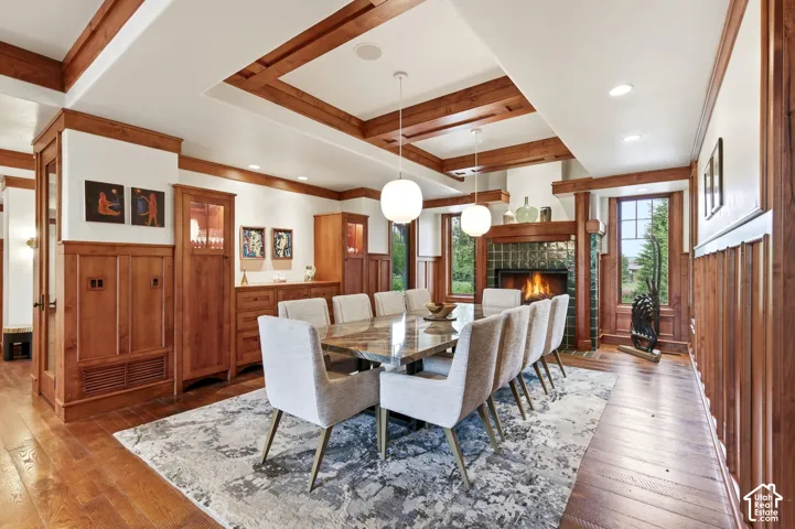 Wood-finish flooring with a decorative area rug, a fireplace with a tile surround, and built-in wood cabinetry