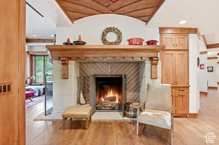 Fireplace with a substantial wooden mantel, stone surround, and diagonal tile inlay