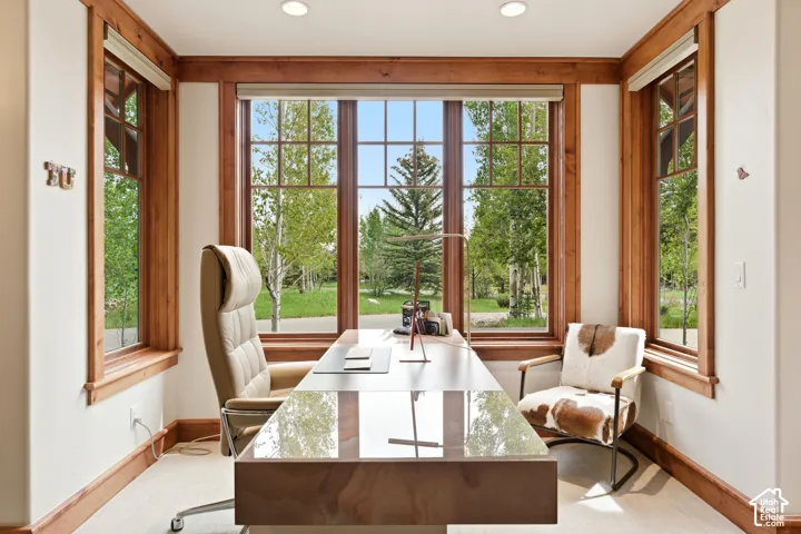 Room featuring multiple windows with natural wood trim, can lighting, and light-colored flooring