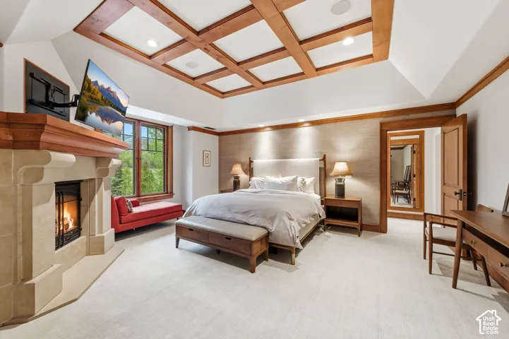 Coffered ceiling with wood accents, stone fireplace, wood-framed windows, built-in lighting, and wood trim detailing